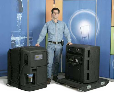 Dean Kamen standing between two black machines, each as big as a dishwasher