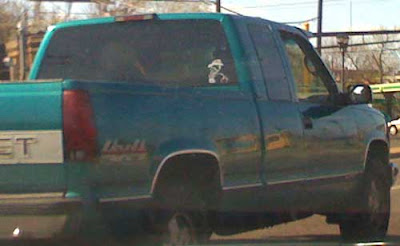 Green Chevy pickup truck with sticker of Calvin peeing in the back window