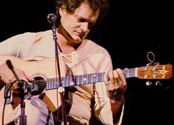 Photo of Harry Chapin playing a guitar in concert