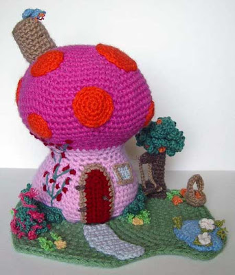 Colorful crocheted mushroom house with landscaping