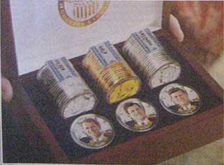 Close up of the brown treasure chest box with three tubes of coins and three coins with color pictures of the Kennedy brothers
