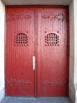 Red-painted doors with metal details as are found on church doors