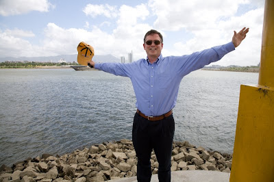 Jim Fruchterman with arms spread wide by a river