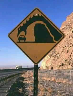 photo of a road sign with a sea monster eating a car