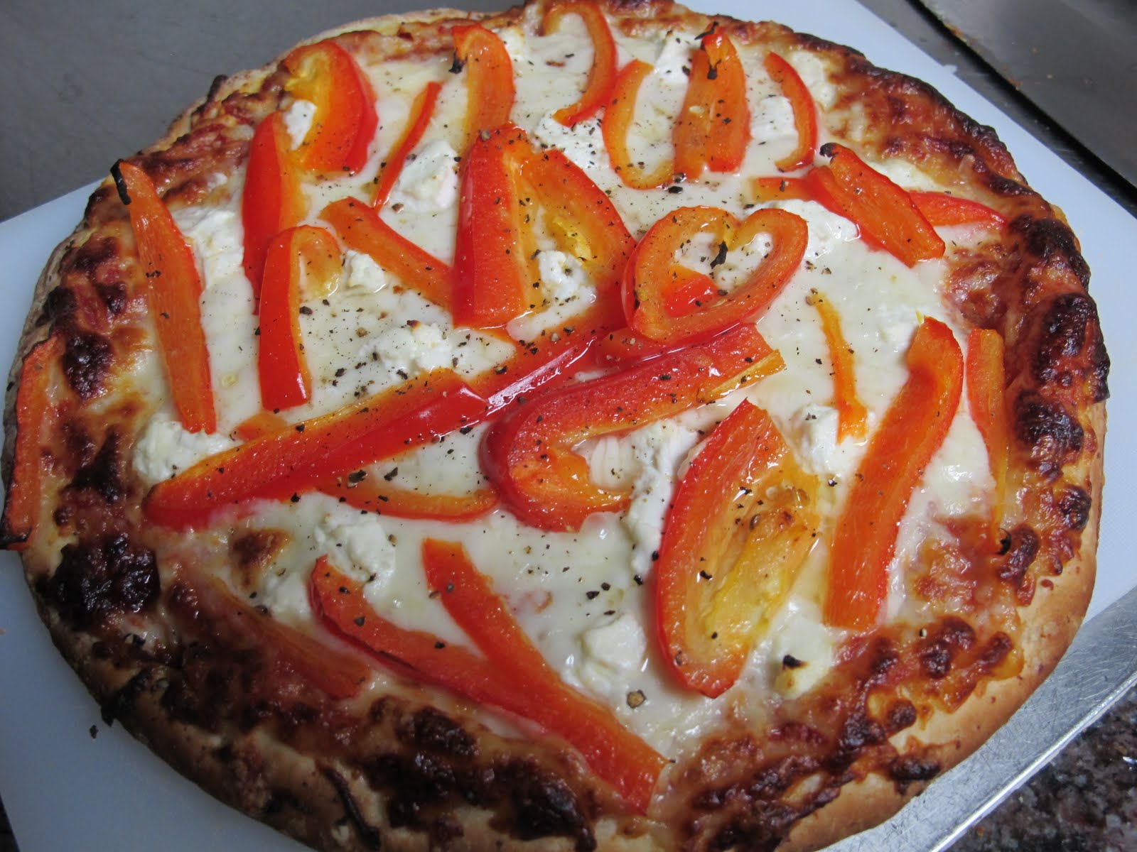 Classy Eats Mozzarella and goat cheese pizza with red peppers.