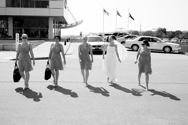 Black and White candid of Bride and bridesmaids walking by Discovery World before wedding