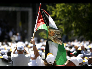 People and pilgrims celebrating the arrival of Pope Benedict XVI, a man with Palestinian flag picture