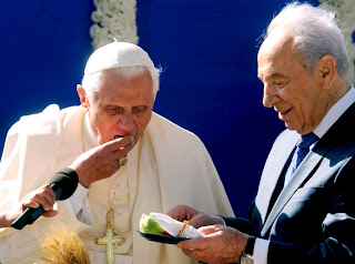 Pope Benedict XVI eating a date in the welcoming ceremony at the presidential residence in Jerusalem photo