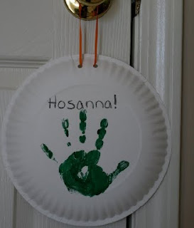 Paper plate with paint handprint reading "hosanna"
