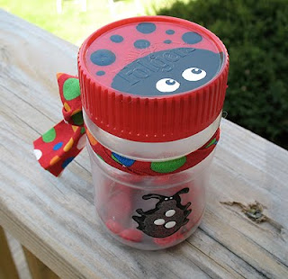 Jar with a ladybug painted on top and a ribbon around it