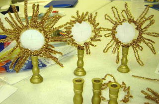 Plastic candle sticks with Eucharist crafts on top