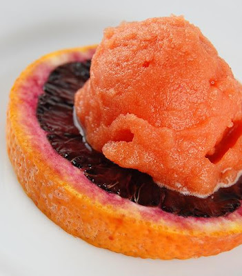 Blood orange slice with scoop of orange sorbet on top of it