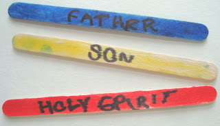 Blue, yellow, and red popsicle sticks reading Father, Son, and Holy Spirit