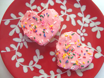 Hert-shaped snacks with sprinkles and pink cream cheese.