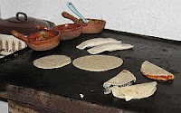 A color photo of a large cast iron comal or griddle.