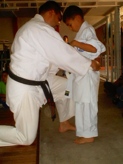 le sensei eduardo arreglandole el karategui a su hijo