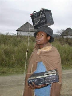 totally really funny photo of man carrying a stereo with a large battery on his head for power