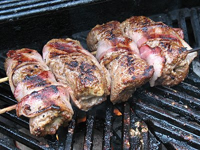 A close up photo of grilled cube steak rollups on the grill.