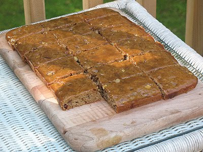 A photo of applesauce spice bars resting on a wooden cutting board.