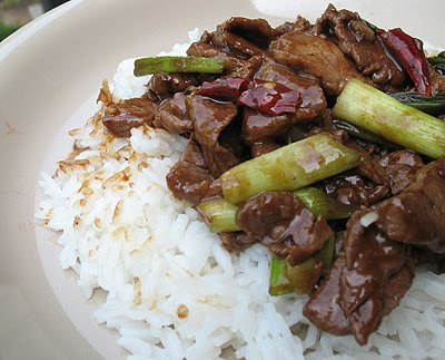 A close up photo of stir fried spicy beef over rice.