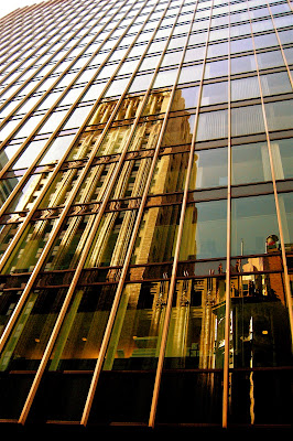 photo of glass building in downtown San Francisco with reflection of an older building