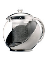 Photo of a metal and glass teapot.
